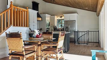 Un'ampia cucina con zona pranzo, scala in legno e vista sull'esterno.