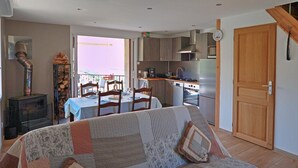 A compact living space with a dining area, kitchenette, and a sofa.