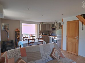 A compact living space with a dining area, kitchenette, and a sofa.
