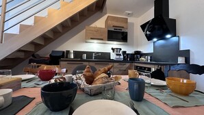 Een moderne keuken met houten kastjes, een ingebouwde oven en een grote flatscreen-televisie.