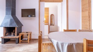 Ein modernes Zimmer mit Kamin, Holzmöbeln und Fernseher.