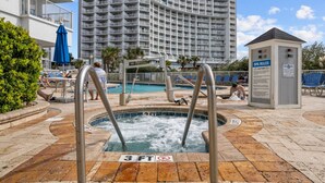 A pool area with a hot tub, a sign indicating a 3ft depth limit, and a sign with spa rules. - Penthouse SeaWatch Ocean Front (Myrtle Beach)