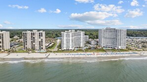 A beachfront hotel with multiple high-rise buildings, a sandy beach, and a clear view of the ocean. - Penthouse SeaWatch Ocean Front (Myrtle Beach)