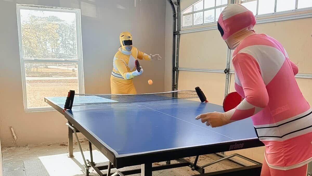 Ein Tischtennistisch in einem Raum mit Fenster und Tür.