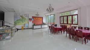 A spacious hotel lobby with a reception desk, a staircase, and a dining area with tables and chairs. - Jieya Hotel (Emeishan City)