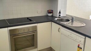 A kitchen with a built-in oven, a dishwasher, and a sink.