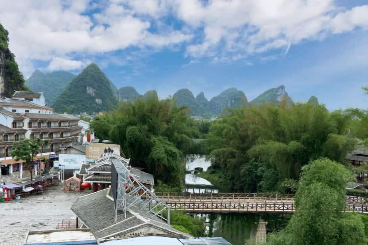 A traditional building with a sloped roof, a wooden bridge, and a river in the background.