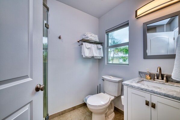 A modern bathroom with a toilet, sink, and a towel rack.