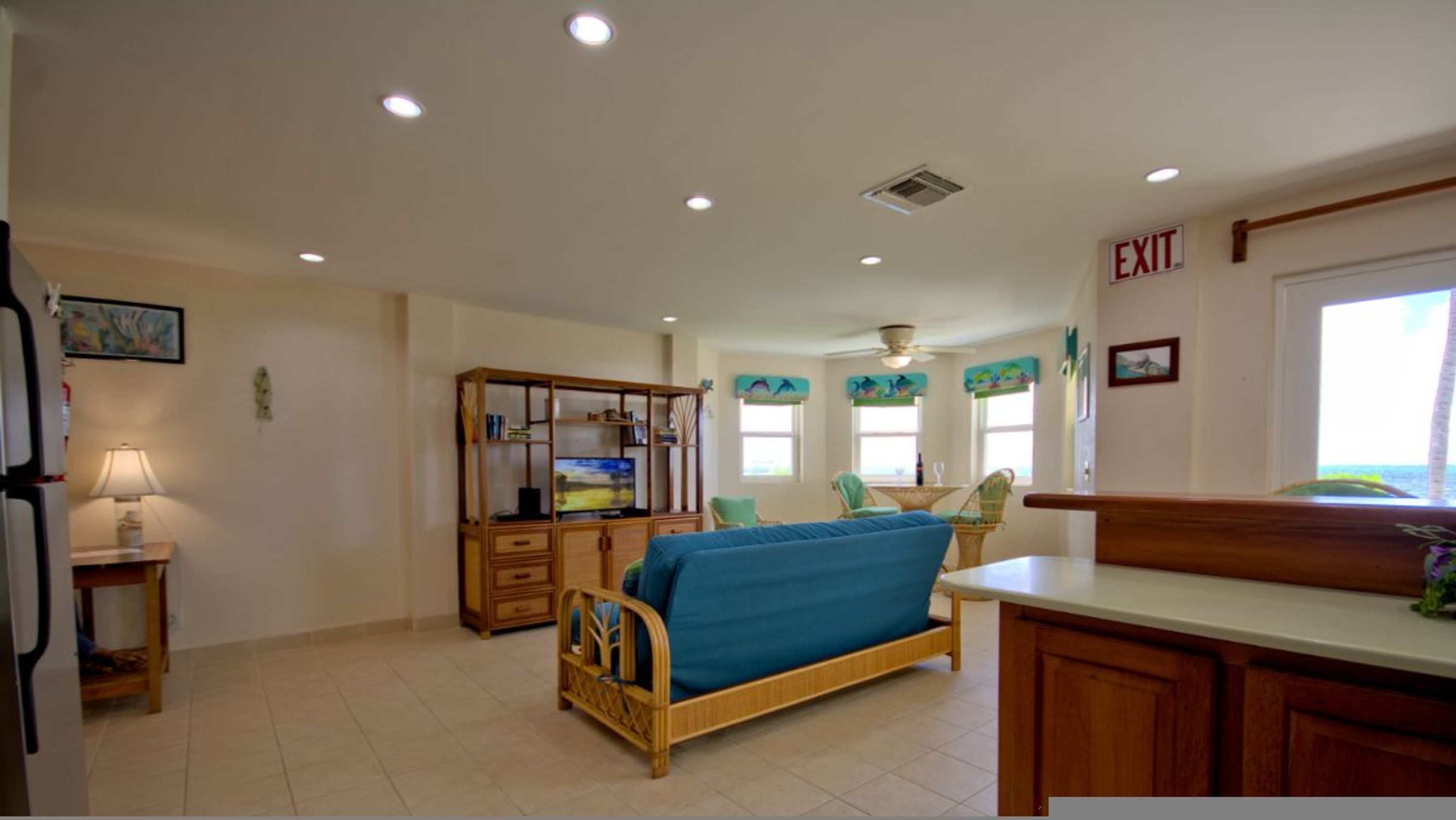 Una habitación con cama, un armario de madera, televisor y un rincón de comedor con sillas.