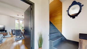 A modern interior with a staircase, a dining area, and a living room. - Apartment Grand Standing 🍀 (Épinay-sur-Seine)