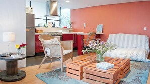 A cozy living area with a sofa, wicker chairs, a coffee table, and a dining table. - Gorgeous studio with WiFi in Napoles (Napoles)