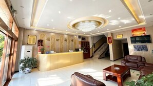A hotel lobby with a reception desk, seating area, staircase, and a chandelier. - Delong Hotel(Fufeng County Hospital Fufeng Bus Station Branch) (Fufeng County)