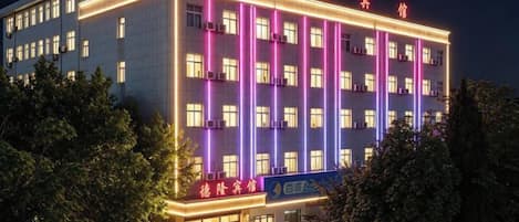 A multi-story hotel with illuminated signage and a well-lit facade.