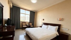 A hotel room with a bed, a desk, a chair, a TV, and a window with curtains. - Delong Hotel(Fufeng County Hospital Fufeng Bus Station Branch) (Fufeng County)