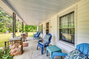 A covered porch with stone pillars, blue chairs, and a small table. - ‘Historic Hawkins House’ Located on Sewanee Campus (Sewanee)