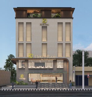 A modern hotel with a prominent logo, large windows, and a well-lit entrance. - Hotel Raai Hosur (Hosur)