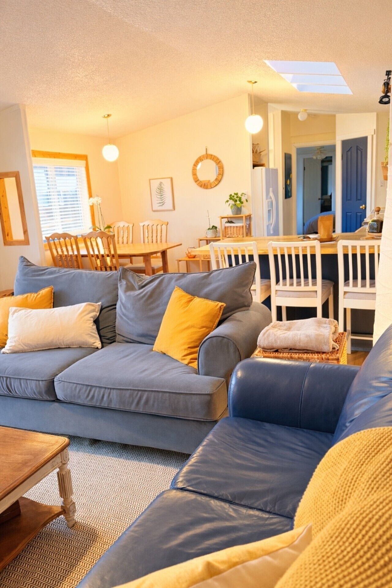 A living room with a sectional sofa, a dining table, and chairs.