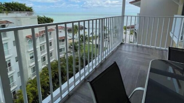 A balcony with a view of the sea, a dining table, and chairs. - Family-Friendly 3BR Beachfront Puntarena (Rio Hato)