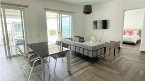 A modern, well-lit room with a dining area, a small kitchen, and a bed. - Family-Friendly 3BR Beachfront Puntarena (Rio Hato)