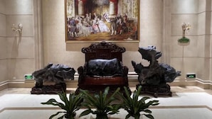 En lobby med et stort klassisk maleri, et flygellignende klaver og to store klippeformationer.
