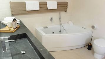 A modern bathroom with a bathtub, a sink, and a toilet.