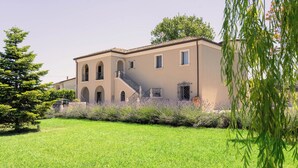 A building with a symmetrical facade, arched windows, and a central staircase. - Ayma B&B (Mirabella Eclano)