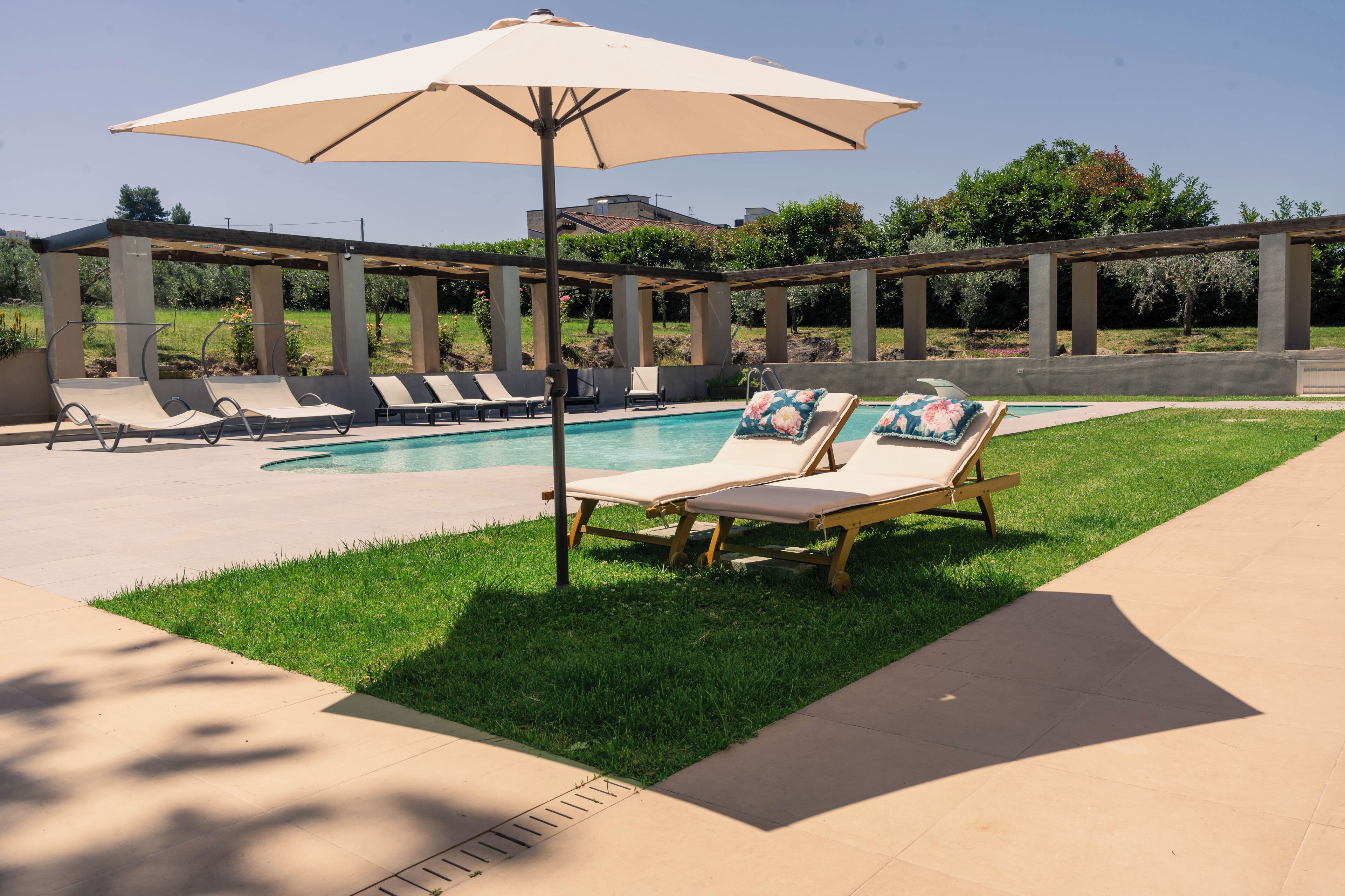 A pool area with lounge chairs and umbrellas.