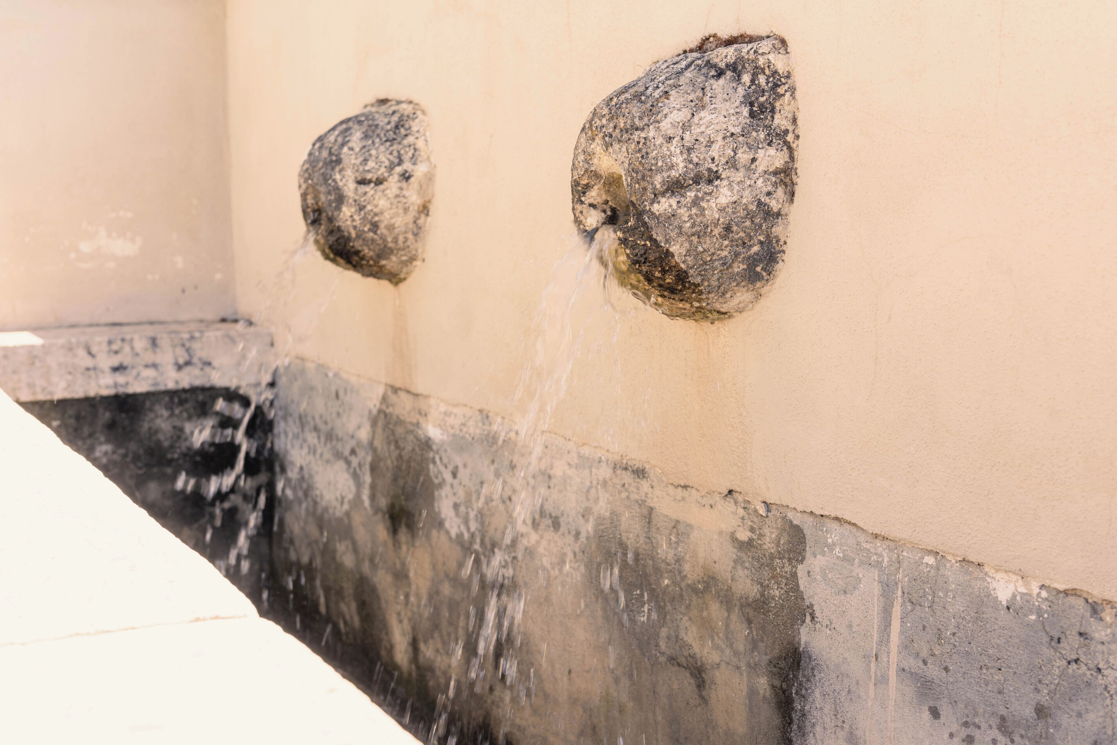 A wall with two water spouts.