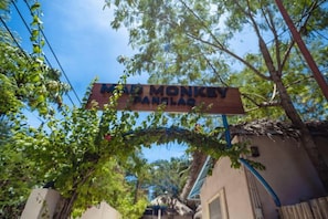 A sign with the text 'ROAD MONKEY PANJANG' in a rural setting with trees and a building in the background. - Mad Monkey Panglao (Panglao Municipality)