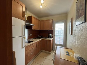 Enjoy meals in this well-lit kitchen with a dining table near the window offering a view of the outside.
