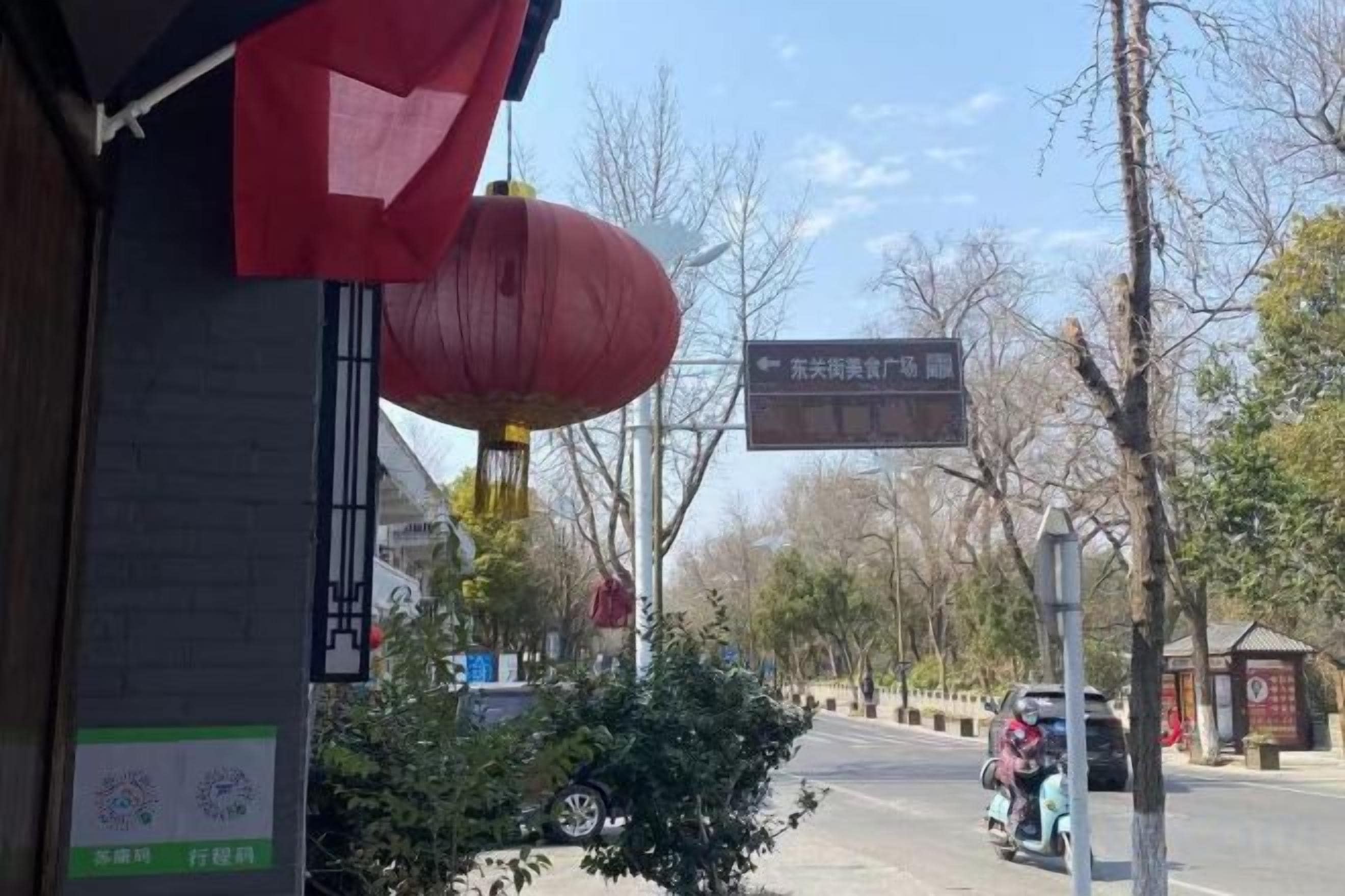 Vista de la calle con un letrero que indica una zona comercial.