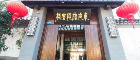 A traditional building entrance with a wooden door and a sign above it.