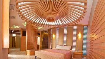A modern bedroom with a large bed, a unique ceiling design, and a wooden wall panel.