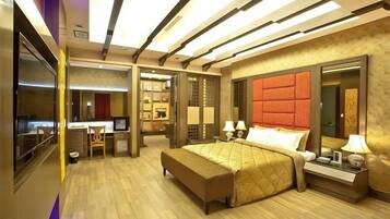 A modern hotel room with a large bed, bedside tables, a desk, and a mirror.