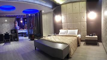 A modern bedroom with a large bed, a bedside table, and a bench.