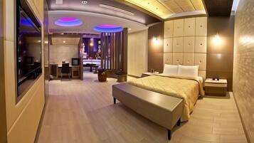 Quarto de hotel moderno com uma cama grande, uma mesa de trabalho e um espaço para sentar.