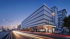 Un hotel moderno con una ubicación destacada en una esquina, que presenta una estructura de varios pisos con amplios ventanales y techo plano.
