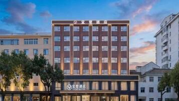 A multi-story hotel building with a modern facade, featuring a prominent signage at the top.