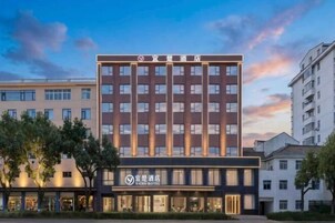 Un edificio de hotel de varios pisos con fachada moderna, que presenta una señalización destacada en la parte superior.