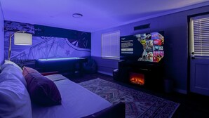 Une chambre avec un lit, une télévision et un mur orné d’une fresque.