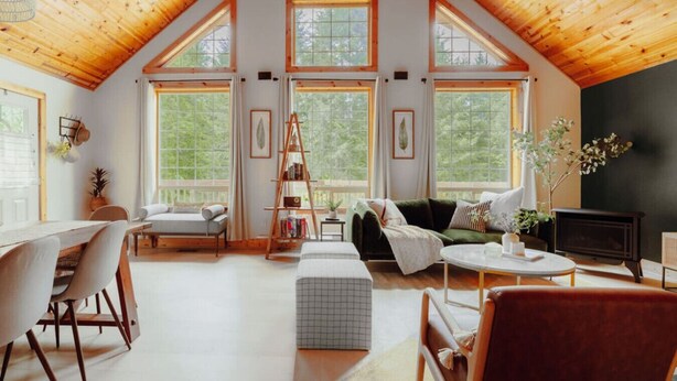 Un loft spacieux avec de hauts plafonds, de grandes fenêtres, un coin salon confortable et une cheminée.