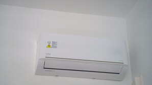 Een luchtverkoeler aan de muur met een waarschuwingsticker en een logo.