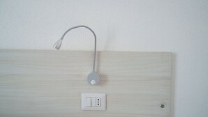 A bathroom with a wooden panel wall, a showerhead, and a light switch. - Das alte Haus - Room 302 (Olbia)