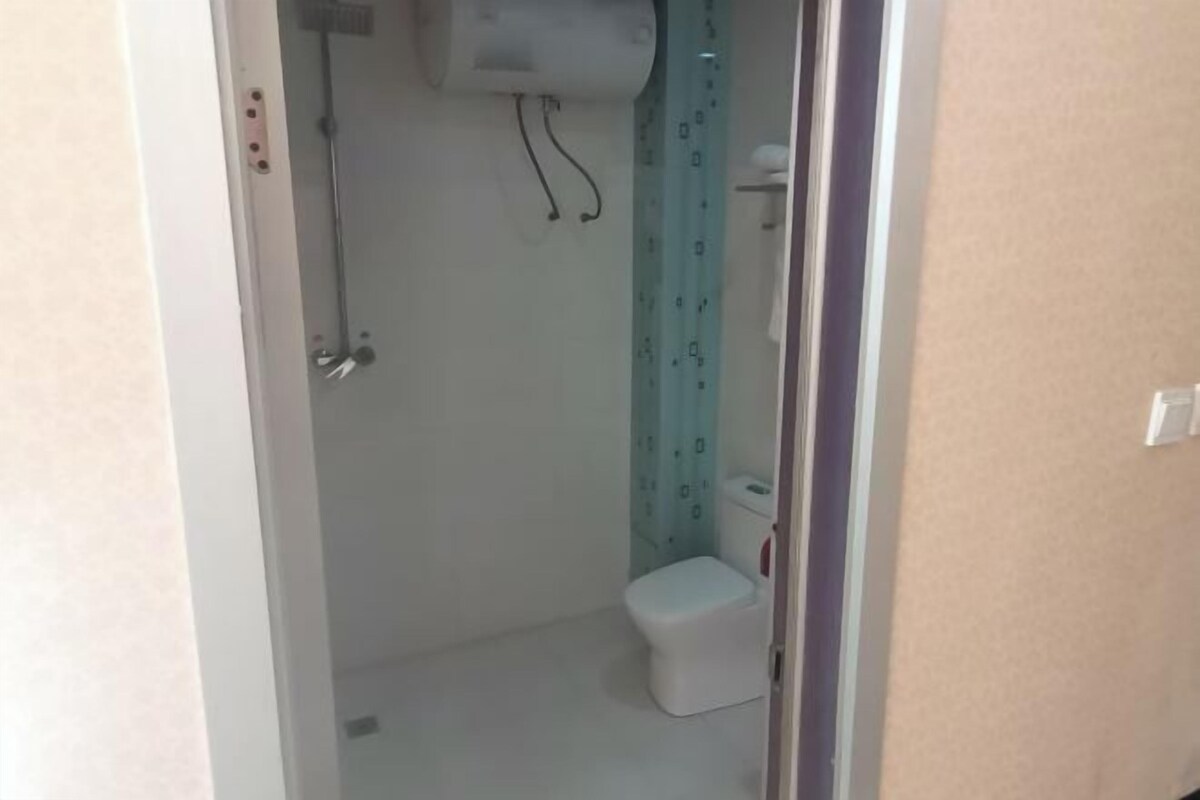 Un baño pequeño y estrecho con un inodoro y una ducha.