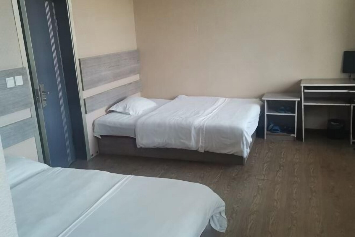 Una habitación de hotel con dos camas, un escritorio y un televisor.