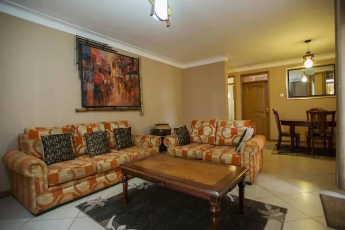 A living room with two sofas, a coffee table, and a painting on the wall.