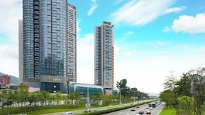 A modern high-rise building with a curved facade, surrounded by a well-maintained urban street with cars and greenery. - GreenTree Eastern Hotel(Shenzhen Jingtian Metro Station Store) (Shenzhen)