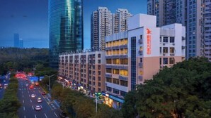 A modern building with multiple floors, surrounded by trees and a busy road. - GreenTree Eastern Hotel(Shenzhen Jingtian Metro Station Store) (Shenzhen)