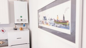 A white Liebherr refrigerator with a digital display, a small wooden boat, and a framed picture of a ship on the wall. - Maison De La Brodeuse by Ca-Sa Check (Chioggia)