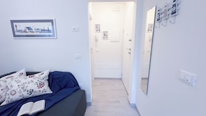 A bedroom with a bed, a bedside table with an open book, a framed picture on the wall, and a door leading to another room. - Maison De La Brodeuse by Ca-Sa Check (Chioggia)